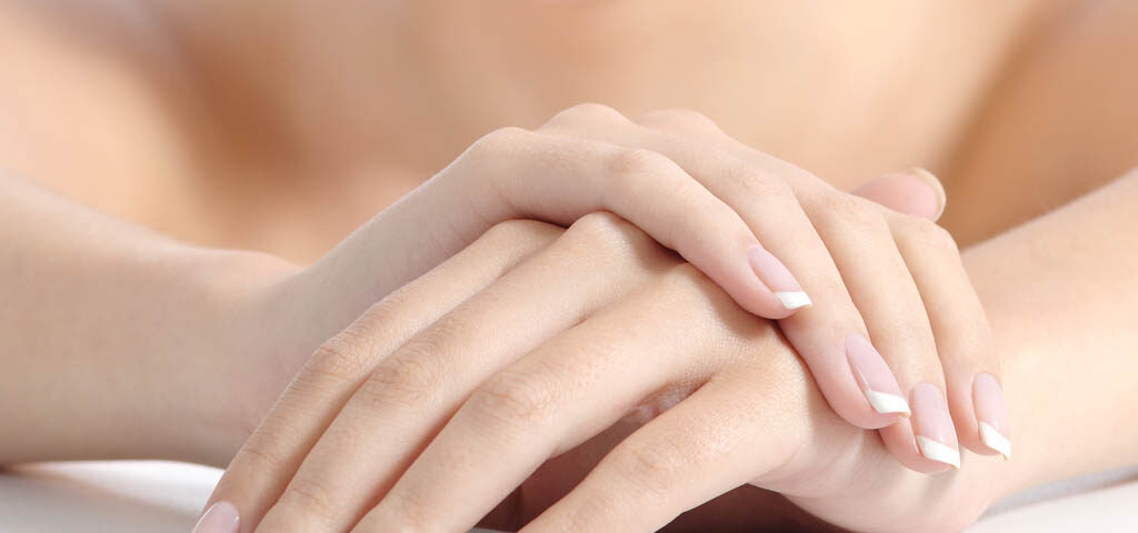 kobieta prezentuje dłonie po zabiegu z kwasem hialuronowym